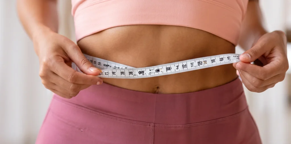 Measuring waist with tape measuring tape representing weight loss facts