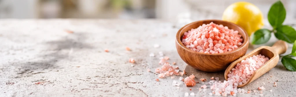 Himalayan pink salt in a wooden bowl with wooden scoop