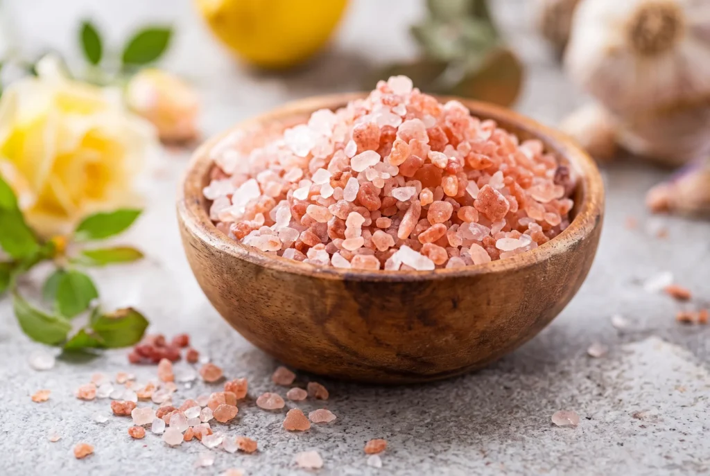 Wooden bowl filled with coarse Himalayan pink salt crystals