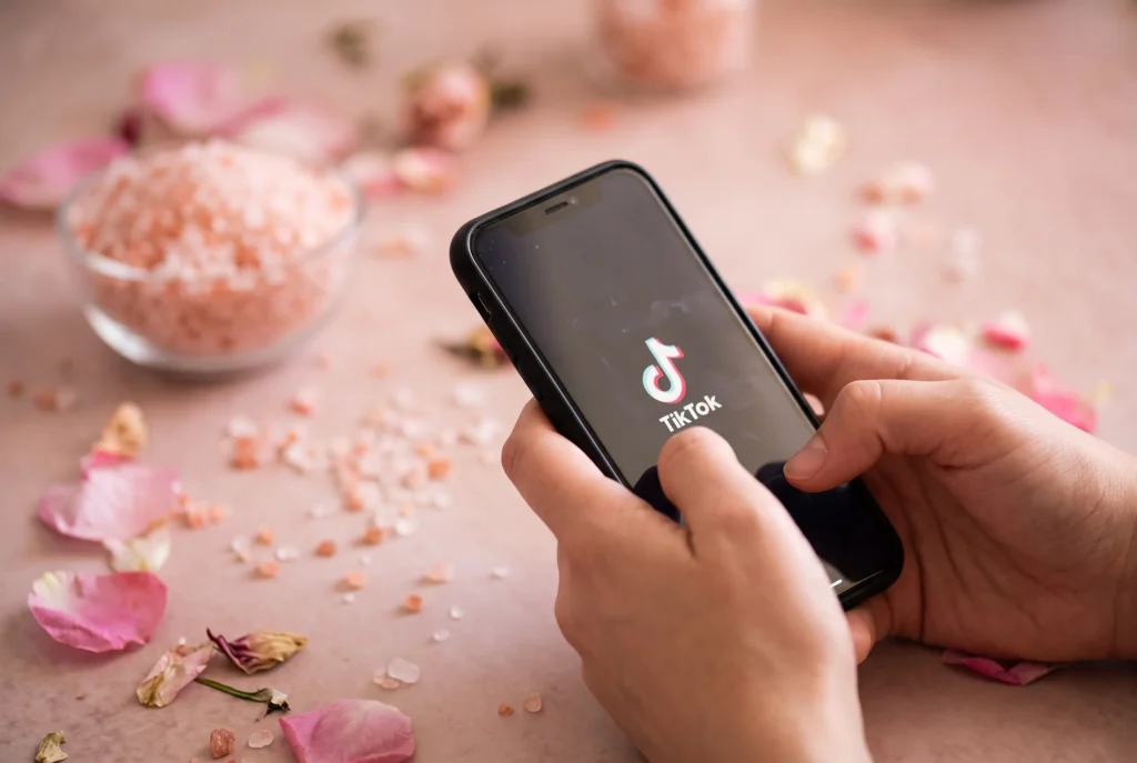 Smartphone displaying TikTok trend surrounded by pink salt